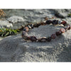 Handmade, natural Flower agate bracelet, beautiful brownish nuances, 2.5x8 mm bead stretch bracelet with a small metal Tibetan style bead, sitting on a rock on the Irish shore in West Cork