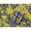 Handmade, natural Amethyst gemstone earrings made with 4 beautiful purple 6x8 mm nuggets. Metal parts are stainless steel. The background is the Irish rocky shore of West Cork.