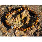 Tiger eye stone bracelet on rock. The stones have beautiful golden and brown nuances and a silky shine.